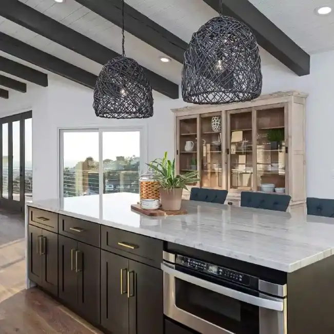 Bright kitchen with dark island cabinetry and stone countertop